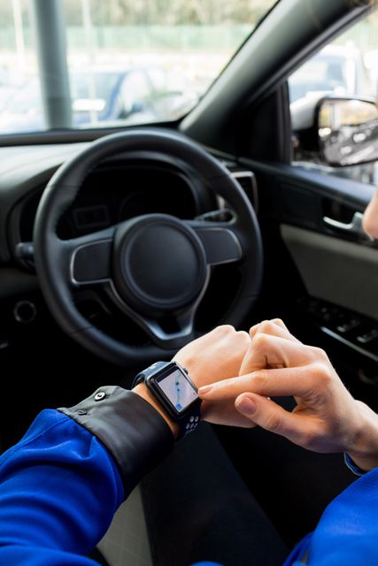 High angle view of woman using smart watch in car during test drive