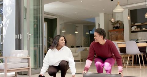 Female Friends Preparing for Home Yoga Session Outdoors