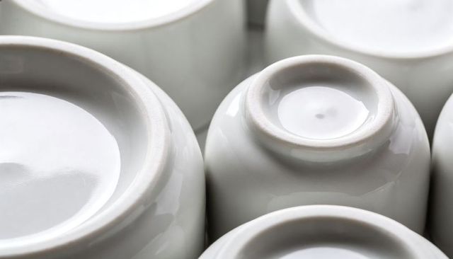 Minimalist white porcelain bowls upside down showing foot rings and glazed reflections