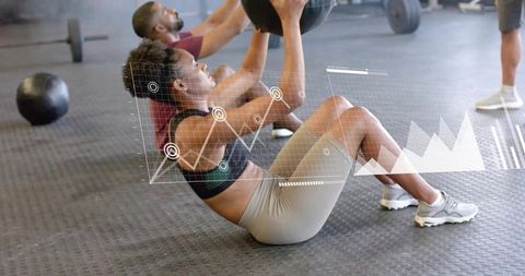 Performing sit-ups with medicine ball in gym with augmented reality fitness data overlay