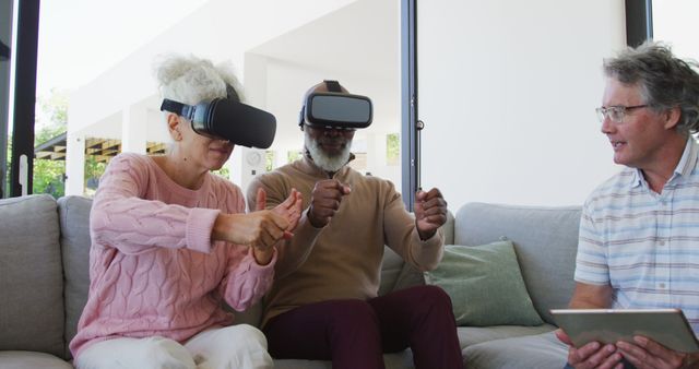Senior couple exploring virtual reality under guidance from an instructor. Image is ideal for tech and educational websites to illustrate senior engagement with modern technology and learning in a relaxed home environment.