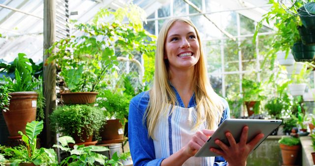 Happy Greenhouse Worker with Tablet Managing Plants - Download Free Stock Images Pikwizard.com