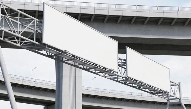 Blank billboards on steel truss over urban highway, advertising space on concrete overpass