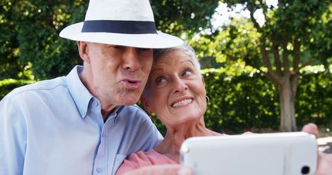 Senior Couple Taking Selfie Outdoors Embraces Joyful Moment