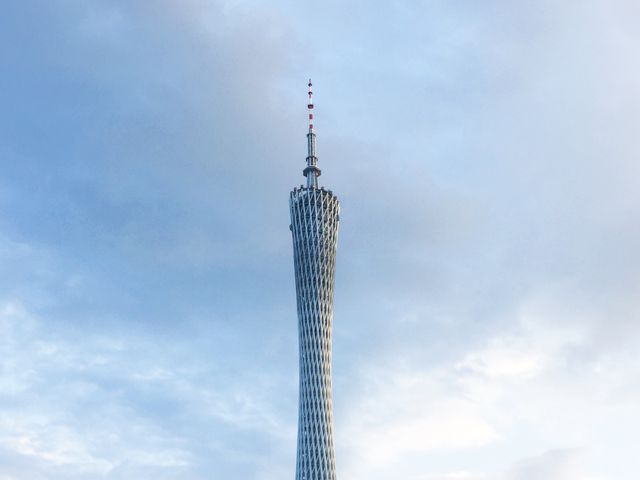 Canton Tower standing tall against a cloudy sky highlights modern architectural design in Guangzhou, China. Suitable for projects focusing on urban landmarks, Chinese architecture, and city skylines. Ideal for travel articles, promotional materials, and educational content about iconic structures.