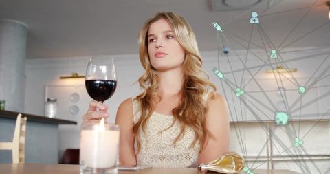 Thoughtful Woman Savoring Red Wine in Elegant Restaurant