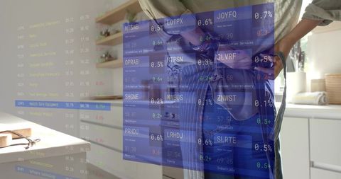 Female entrepreneur viewing virtual stock market overlay in home kitchen with notebook