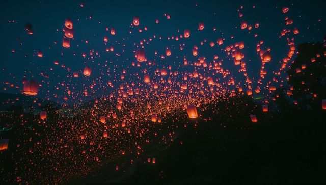 Glowing sky lanterns rising in night festival celebration