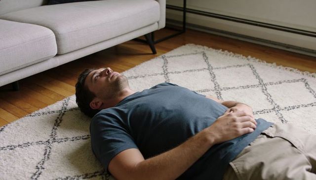 Man relaxing on rug in minimalist living room interior for calm home lifestyle