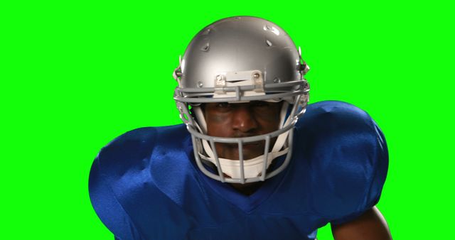 American football player wearing blue jersey and helmet with focused expression on green screen backdrop. Useful for advertising sports equipment, team promotions, and illustrating sports articles.