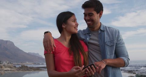 Happy Diverse Couple with Smartphone by Seaside on Vacation - Download Free Stock Images Pikwizard.com