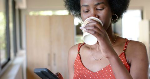 Businesswoman Enjoying Coffee and Checking Smartphone at Office