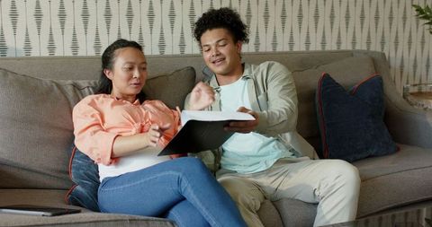 Expectant Couple Relaxing with Tablet Planning Future Together