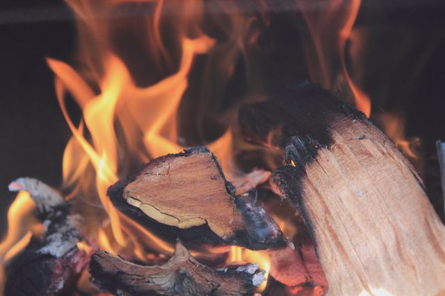 This image captures a close-up view of burning firewood with glowing flames. Great for illustrating warmth, campfire themes, barbecue events, or thermal energy concepts. Ideal for use in nature-related blogs, camping advertisements, fireplace designs, outdoor activities promotions, or as a background image emphasizing heat and light.