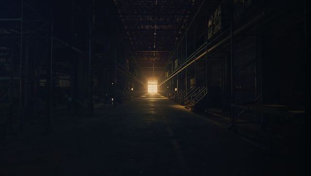 Sunlit Exit in Dark Industrial Warehouse