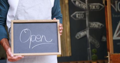 Open Sign Chalkboard Held by Shopkeeper in Apron - Download Free Stock Images Pikwizard.com