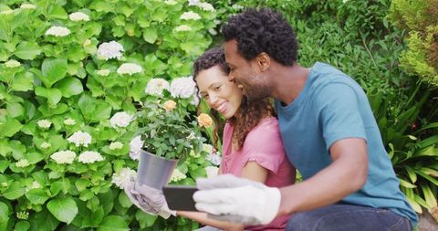 Happy Couple Enjoying Gardening Taking Selfie with Flowers