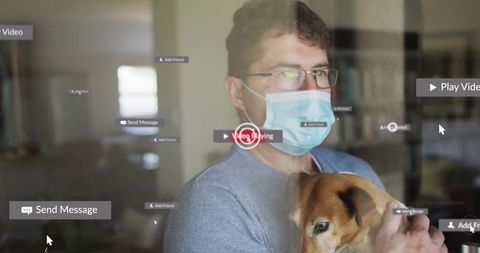 Man in Mask Holding Dog Interacting with Virtual Interface