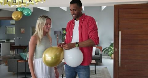 Couple Preparing House for Festive Party with Balloons