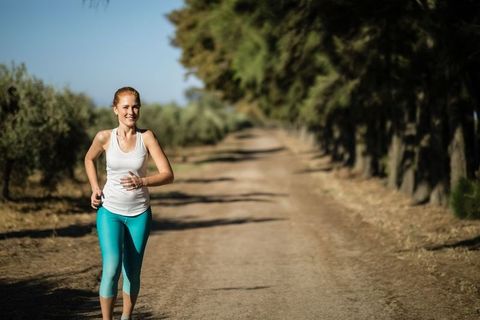 Active Woman Running on Country Road in Scenic Landscape