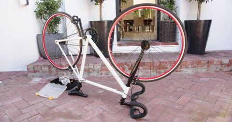 Vintage white bicycle upside down on brick patio ready for repair