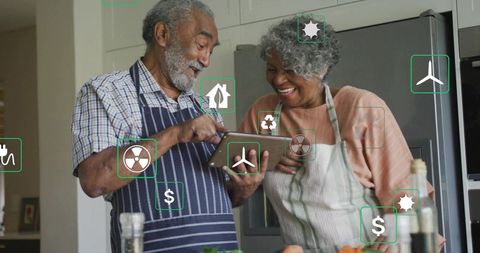Senior Couple Using Tablet in Kitchen Managing Home Energy, Healthy Cooking and Savings