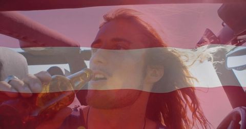 Carefree Young Man Drinking in Convertible with Windblown Hair