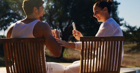 Outdoor Couple Capturing Moments on Smartphone in Sunny Park - Download Free Stock Images Pikwizard.com