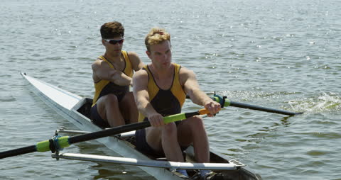 Caucasian Male Rowers Practicing Together in Scull Boat on Sunny Day