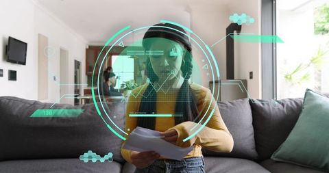 Woman using augmented reality HUD while reviewing documents on modern living room sofa