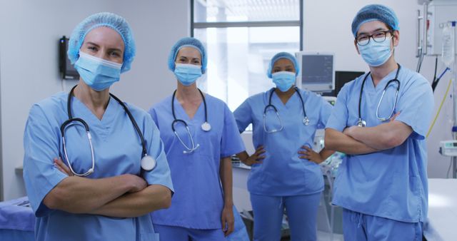 Portrait of diverse female and male surgeons wearing face masks and scrubs in hospital. medicine, health and healthcare services during covid 19 coronavirus pandemic.