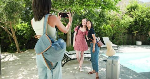 Excited Girls Planning Summer Vacation with Luggage Outdoors