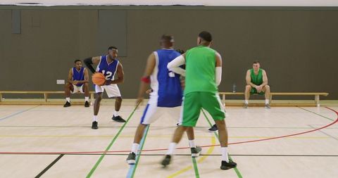 Indoor basketball team practicing defense and inbound pass showing teamwork and athleticism