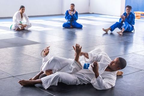 Martial arts training: students grappling on dojo mats