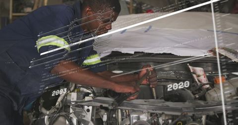 Mechanic Repairing Car Engine Under Hood Using Wrench in Industrial Garage Workshop