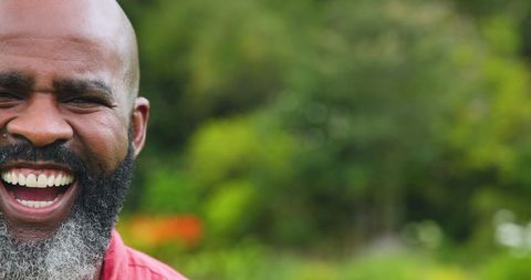 Joyful Senior Man Laughing Outdoors in Garden Setting