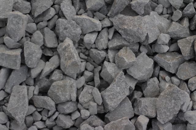 Closeup of small gray gravel stones, often used in construction as a building material or landscaping element. This detailed view captures the texture and variation of sizes among the gravel. Useful in backgrounds, construction project illustrations, or landscaping materials documentation.