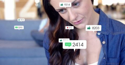 Young woman leaning on couch viewing social media notification bubbles and like counts