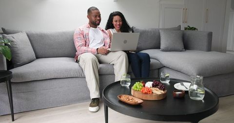 Couple celebrating engagement with video call at home
