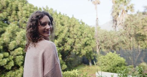 Young Woman Enjoying Nature in Lush Garden