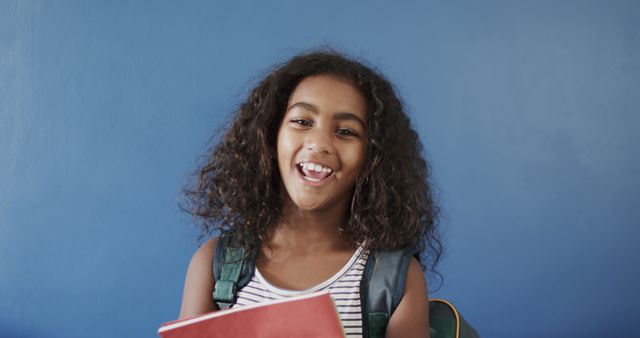 Happy Child Laughing Holding Notebook by Blue Wall - Download Free Stock Images Pikwizard.com