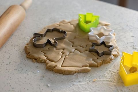 Cutting Holiday Cookies on Speckled Countertop with Rolling Pin and Star Cutters