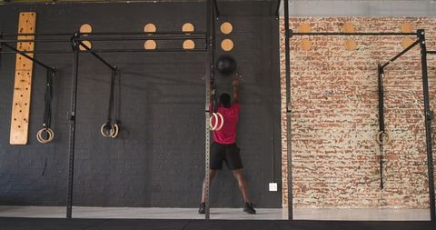 Athletic Man Tossing Medicine Ball During Intense Gym Workout