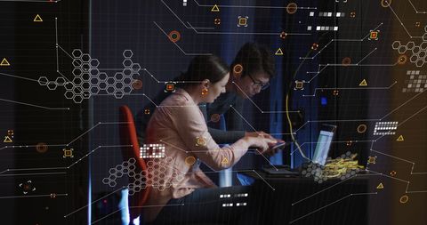 Diverse it technicians working with digital interfaces and data