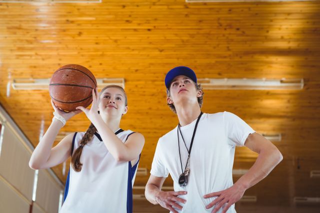 Low angle view of male coach advising female basketball player - Download Free Stock Photos Pikwizard.com