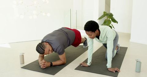 Energetic Fitness Partners Training with Yoga Poses on Mats
