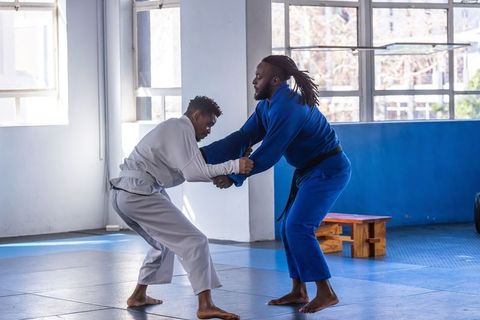 Two Men Sparring in Martial Arts Studio for Discipline and Fitness