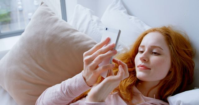 Relaxed Redheaded Woman Using Smartphone on Bed - Download Free Stock Images Pikwizard.com