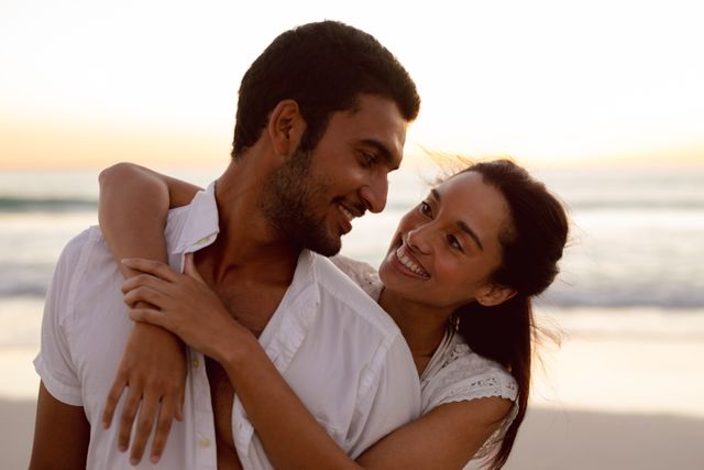 Young couple enjoying a romantic moment at the beach during sunset. Perfect for advertisements, travel blogs, relationship advice sites, vacation brochures, and lifestyle magazines highlighting romance and relaxation.