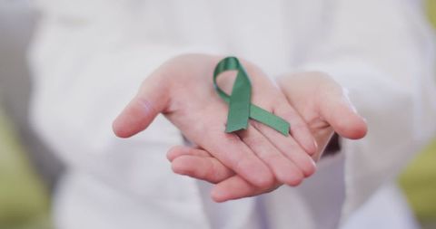 Healthcare Professional Presenting Green Awareness Ribbon in Hands